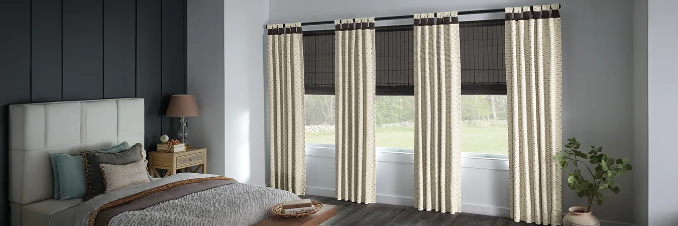 Beige patterned drapes with gray window shades on bedroom windows