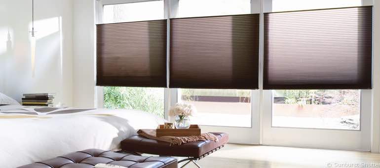 Contemporary St. George bedroom with high windows and vertical honeycomb shades.