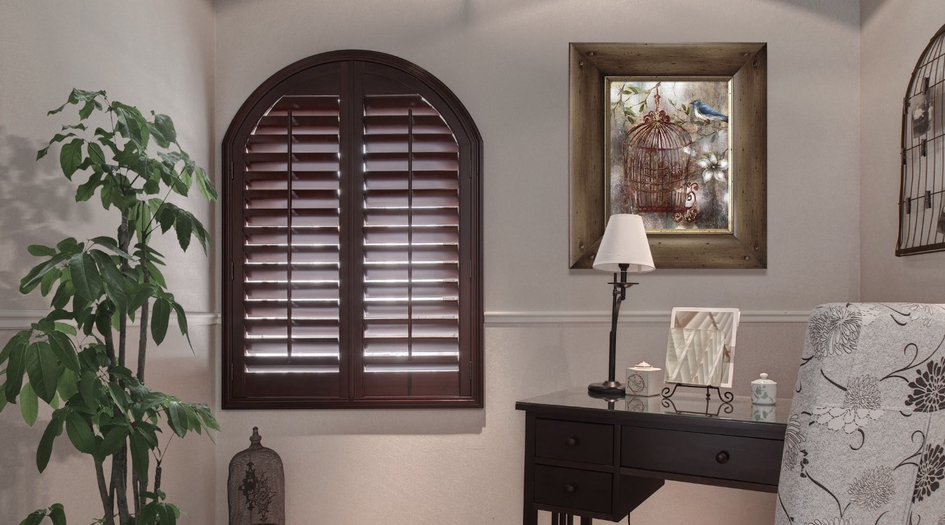 Arched hardwood shutters in bedroom