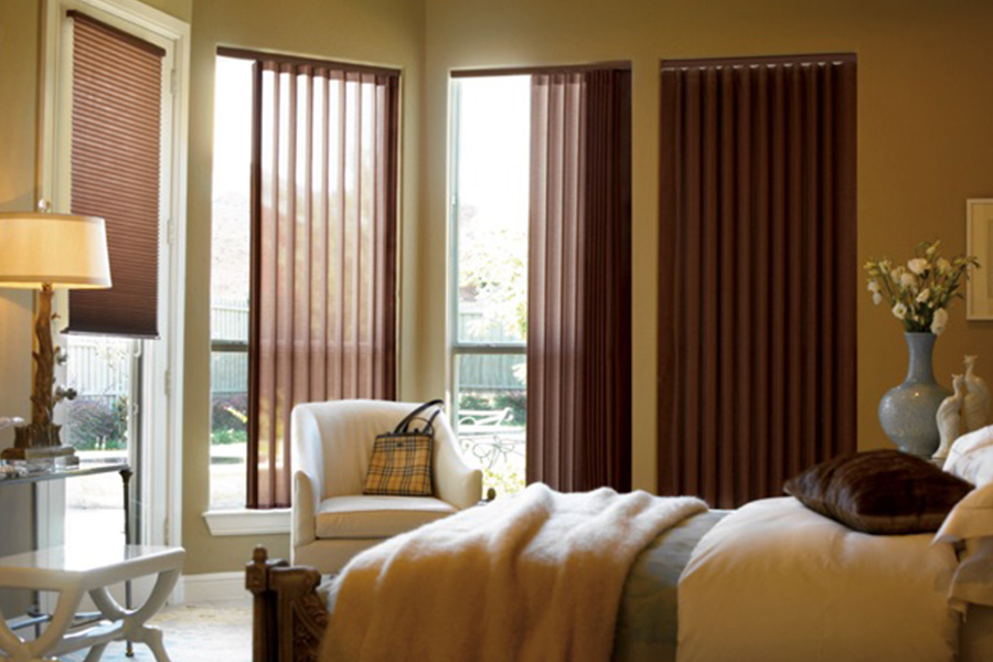 Choose durable and high-quality fabric or vinyl vertical blinds in St. George. Maroon fabric vertical blinds inside a bedroom