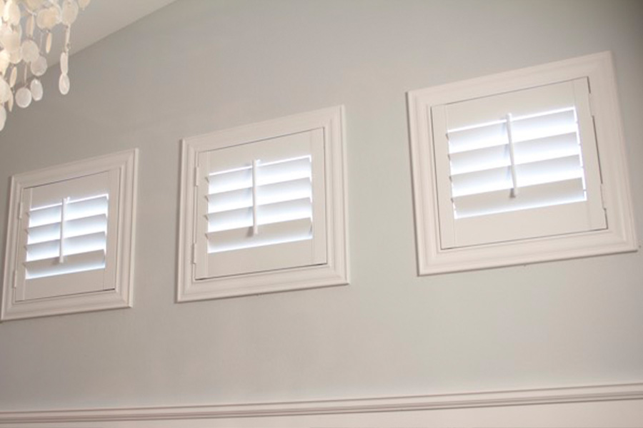 Three casement windows covered by custom plantation shutters.