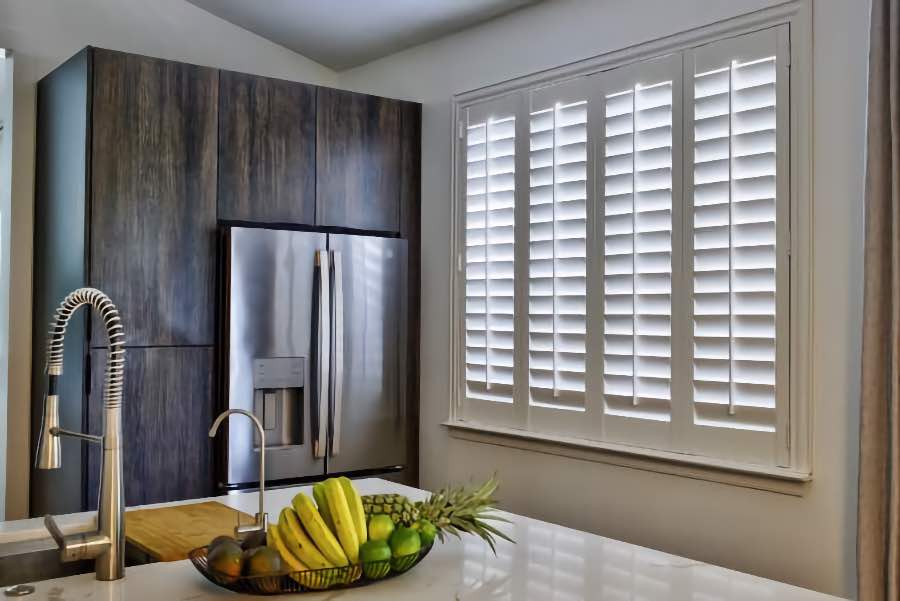 Homeowners use indoor window shutters in St. George when they want attractive and functional window treatments. Polywood shutters on a large kitchen window