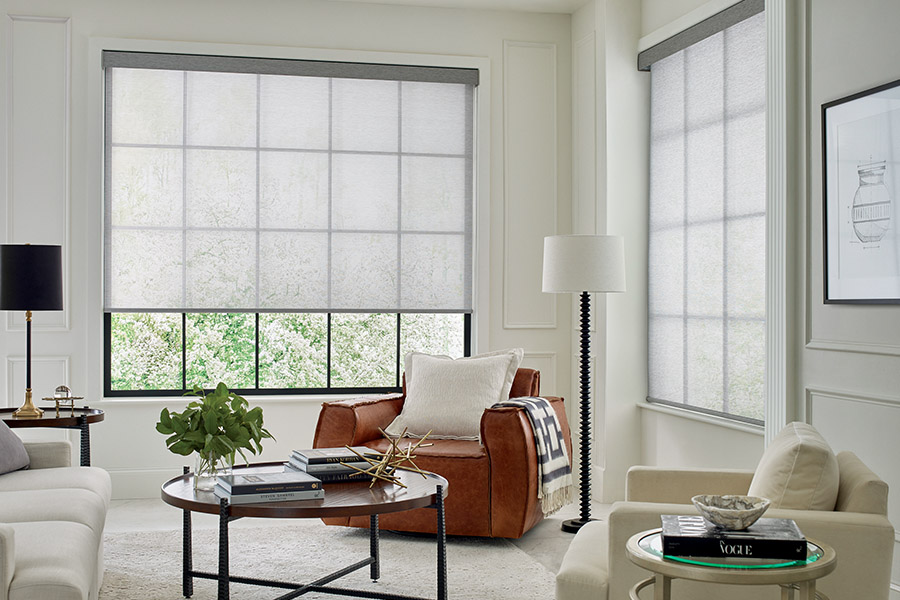 Light gray sheer shades on two large tall windows with a beige and tan styled living room.