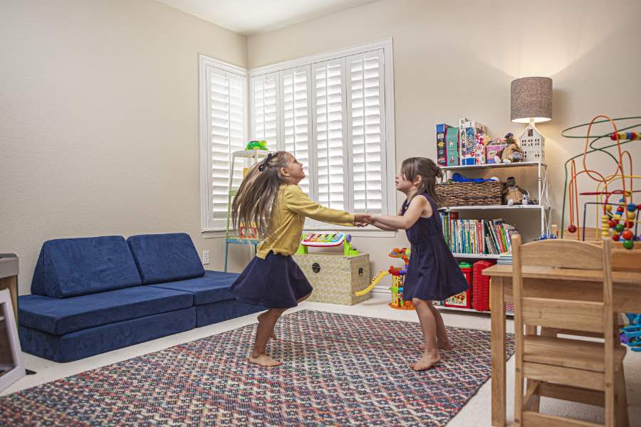 Choose Polywood shutters for durable, kid-friendly great room window treatments in St. George. Polywood shutters on multiple windows in a sitting area