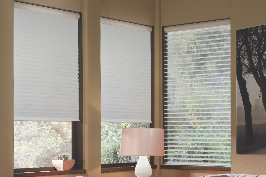 Opaque motorized window shades in St. George keep hot UV rays out of your home. Gray motorized sheer shades on corner windows next to gray furniture