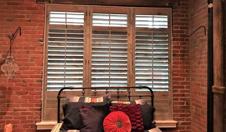 Reclaimed wood shutters give a natural touch to your minimalist design. Reclaimed wood shutters surrounded by brick wall.