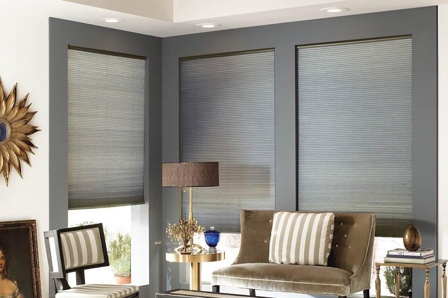 Add style and comfort to your home with cellular shades in St. George. Gray cellular shades in a corner of a stylish living room.