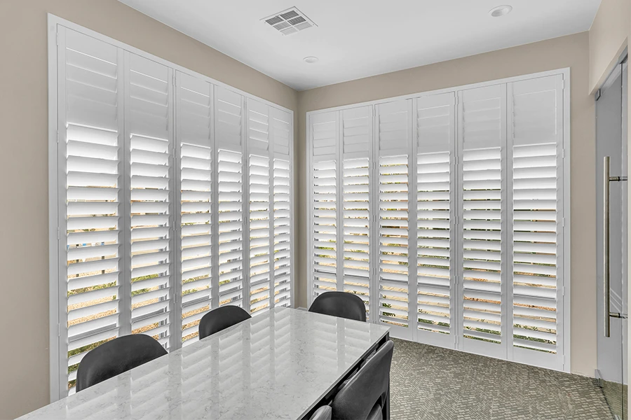 White Polywood shutters with a split tilt function on two large windows.