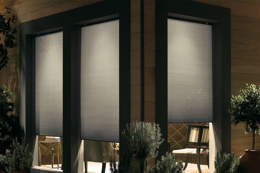 Cellular shades are modern and stylish window treatments for your home in St. George. Dark gray cellular shades displayed from the exterior of a home.
