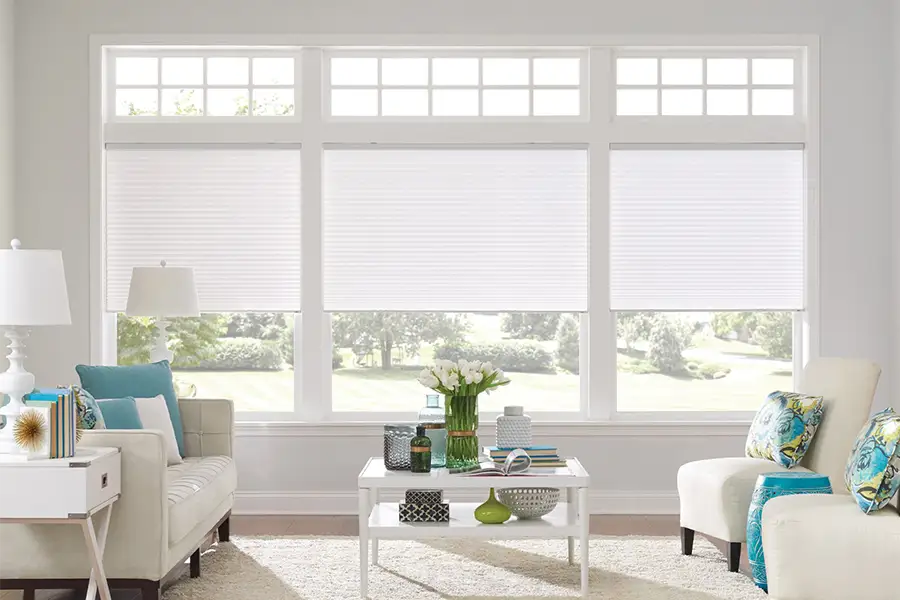 Insulating cellular shades can help keep cold air and hot UV rays from entering your St. George home. White cellular shades on windows in a white living room